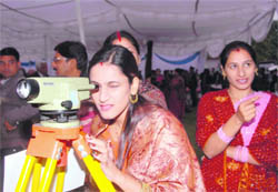 The wife of a naval officer looks through a telescope during the Naval Week celebrations at the National Hydrographic Office in Dehradun on Friday.