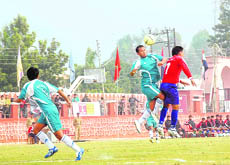 Two players vie for the ball during a semifinal match of the All-India Police Football Tournament in Dehradun 