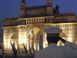 A Navy personnel salutes as the National Anthem is played on the final day of annual Navy Day celebrations at Gateway of India in Mumbai on Friday.