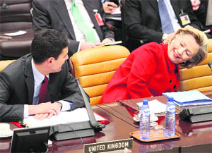 US Secretary of State Hillary Clinton adjusts her seat as she talks with British Foreign Secretary David Miliband at the NATO Foreign Ministers Meeting in Brussels on Friday. Clinton is in Brussels for talks aimed at rallying more allied support for the Obama administration's plan to escalate the war in Afghanistan.