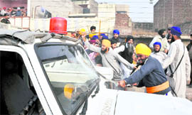 Sikh activists attack a police vehicle.