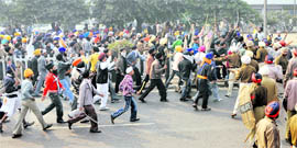 A swarm of armed agitators challenges policemen.