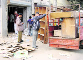 Shopkeepers remove goods from their shops near the Phillaur railway station on Saturday.