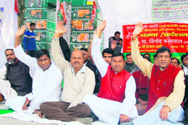 Samajwadi Party workers sit on dharna on the anniversary of the Babri Masjid demolition at the Gandhi Park in Dehradun on Sunday.
