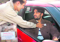 A volunteer pins a flag on the jacket of a Panjab University student on the occasion of the Armed Forces Flag Day in Chandigarh