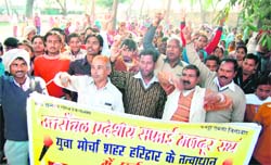 Workers under the aegis of the Uttaranchal Pradesh Safai Mazdoor Sangh, hold a protest in Haridwar on Monday. 