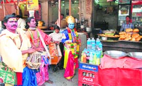 Artistes dressed in a mythological attires earning their livelihood