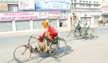 A physically challenged man goes past closed shops on his tricycle in Jalandhar on Monday. 