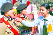 Volunteers pin flags on NCC cadets during Armed Forces Flag Day in Jalandhar on Monday.