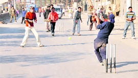 Residents play cricket on a street in Ludhiana on Monday.