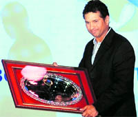 REWARDING THE MASTER: Sachin Tendulkar holds a commemorative plaque at the BCCI annual awards function in Mumbai on Sunday.  AFP