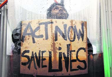 A Maldives climate activist holds a sign as he is submerged in water outside the Bella Center on the opening day of the summit in Copenhagen on Monday.