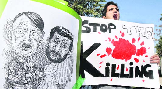 Iranian protesters hold picture showing Iran's President Mahmoud Ahmadinejad and Hitler during a rally in Islamabad on Monday. Protesters condemned the crackdown in Tehran University by the government. 