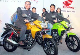 Honda Motor India CEO Masahiro Takedagawa and Honda Motorcycle and Scooter India CEO Shinji Aoyama pose on a new Honda 110 cc CB Twister bike at its launch in New Delhi on Thursday. The bike is priced at Rs 42,000.