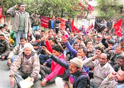 Employees of the Jal Nigam stage a dharna in front of the Secretariat in Dehradun on Thursday. 