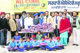 Members of Raikot Lions Club with children of Government Elementary School in Talwandi Rai village.