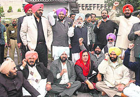 Congress MLAs stage a protest in front of the state Vidhan Sabha in Chandigarh on Thursday.