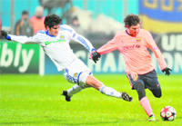 FC Barcelonas Lionel Messi (R) vies with Leandro Almeida during their match
