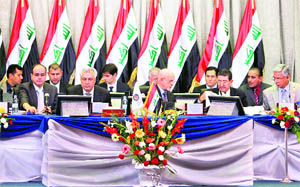 Iraqi Oil Minister Hussein al-Shahristani (C) talks to consultants during a bidding round for oilfields in Baghdad on Friday