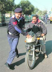 A cop tries to stop a traffic rule violator in Jammu