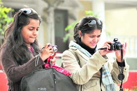 Two girls click photographs at the passing-out parade of Indian Military Academy in Dehradun on Saturday.