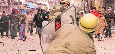 Policemen take cover as youths pelt them with stones at Maisuma in Srinagar on Saturday.