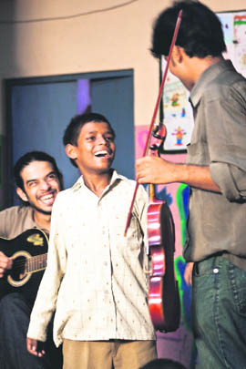 Adheer Gosh of Music Basti interacts with a child during a music workshop conducted for homeless children in Delhi