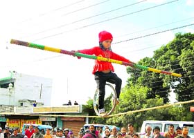 A young girl performs a balancing act on a tight rope at a roadside show in Dehradun