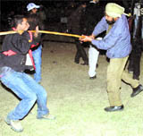 Policemen cane charge a youth during a musical night in Jammu on Saturday night.