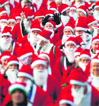 Runners dressed up in Santa Claus outfits jog together during The Great Scottish Santa Run in Princes Street gardens in Edinburgh, Scotland, on Sunday.