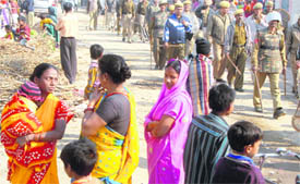 Residents of Colony No. 5 look on as cops guard the area during a demolition drive on Monday.