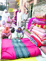 With temperature dipping, these women in Rohtak are busy preparing quilts at a shop. Photo: Manoj Dhaka