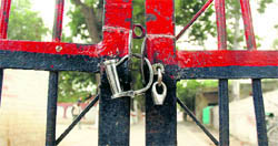 A set of handcuffs used to lock up a gate of the Police Lines near Gurgaon bus stand. Tribune photo: Sayeed Ahmed