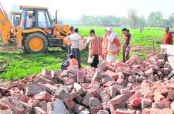 A demolition drive under way at Dadu Majra in Chandigarh on Tuesday. 