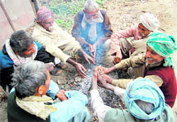 With mercury dropping in the region with an overcast sky, labourers try to keep themselves warm around a bonfire in Dehradun on Tuesday. Tribune photo: