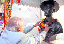 A person garlands the statue of a martyr soldier at Dakra Shaheed Chowk in Dehradun on Wednesday