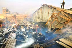 A fireman douses flames at the Garg Acrylics plant in Ludhiana