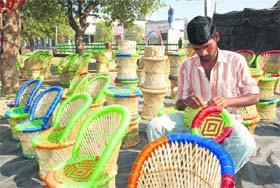 A craftsman gives finishing touches to a cane chair in Hisar