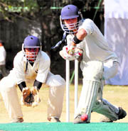 A batsman defends a delivery during a match at the Winter Cricket Festival in Dehradun on Friday. A Tribune photograph