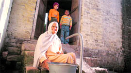 An old woman awaits water supply at Thalodi village in Jammu.