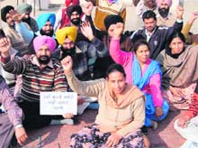 Non-teaching staff of Khalsa College sit on a dharna in Patiala on Saturday. 