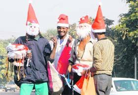 COLOURFUL CHRISTMAS: A seller is all smiles as he spreads the spirit of Yuletide by selling Santa caps and masks in Chandigarh