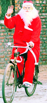 A Santa Claus rides a bicycle in Faridabad.