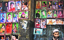 Indian flavour in Pakistan: A poster vendor waits for customers in Rawalpindi on Sunday