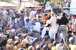 Uttarakhand Congress chief Yashpal Arya (with garlands) and party workers try to break police cordon;