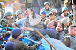 The police prevents a Congress worker from crossing over a barricade in Dehradun on Monday.