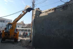 BMC staff demolishing a structure on Goniana road in Bathinda