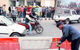 A policeman blocks the road to regulate traffic in Jammus Bikram Chowk