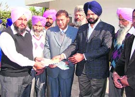 Cheques being handed over for the development project at Detwal village in Kullanpur Dakha