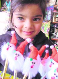 A girl shows Santa Claus toys in Ludhiana